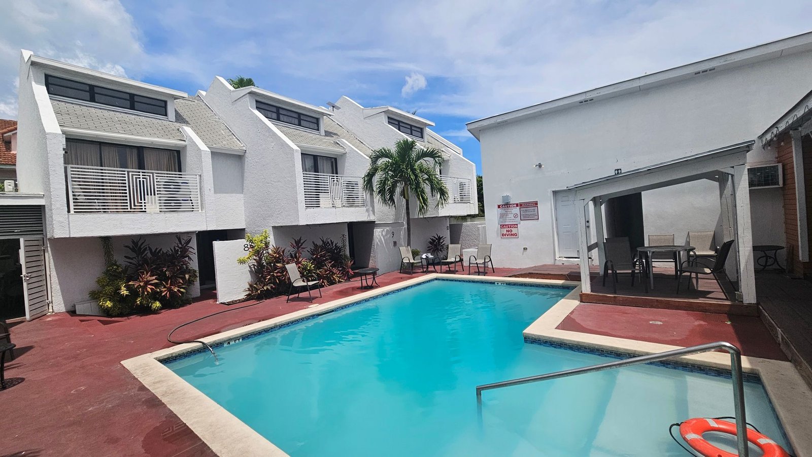 White townhouse complex around a turquoise pool
