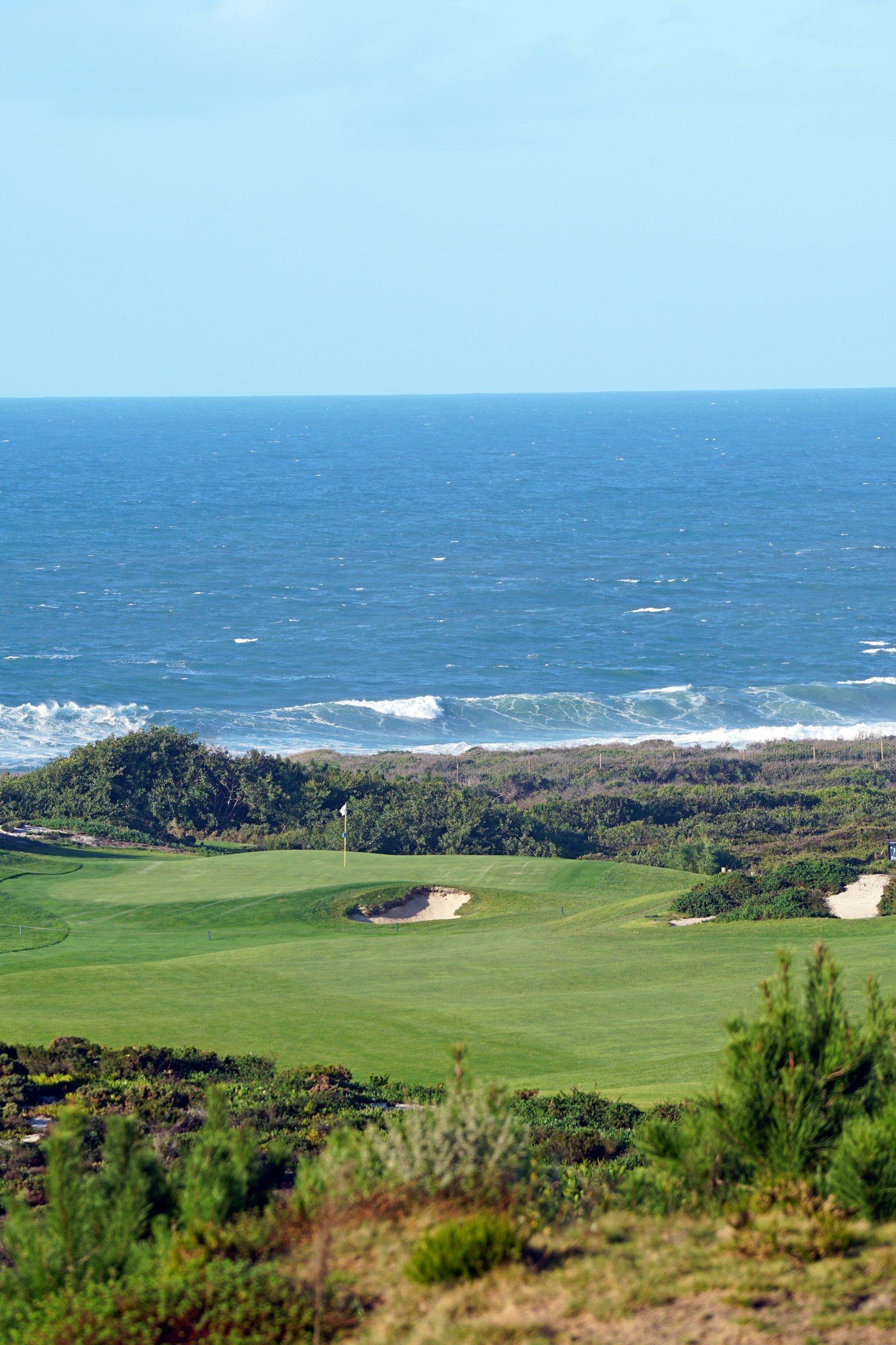 Oceanside golf course with dunes and turquoise water